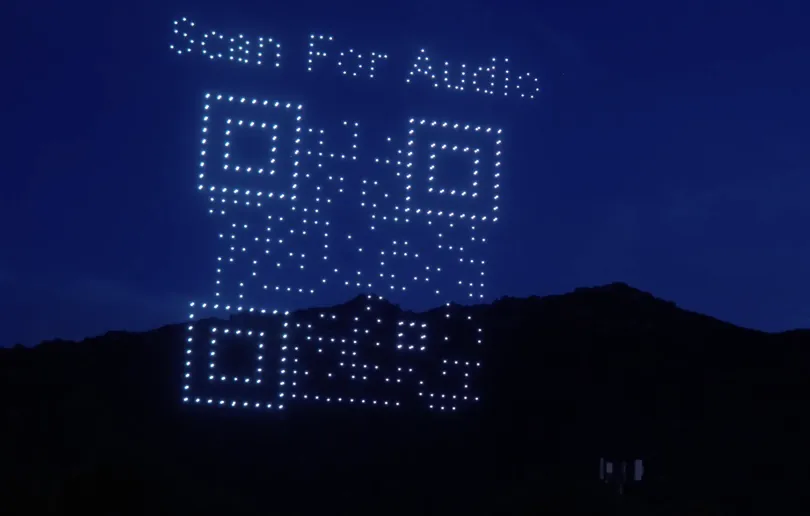 A scannable QR code formed by drones in the night sky for SkyRender Sync audio