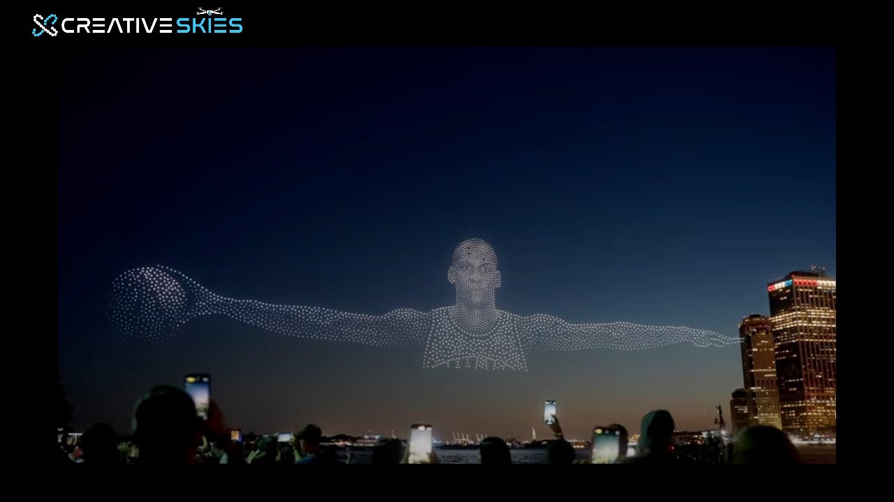 A branded drone formation lighting up the night sky above a live audience