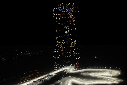 Drone light show forming a Formula 1 animation above a racetrack at night, creating a dynamic motorsport experience.