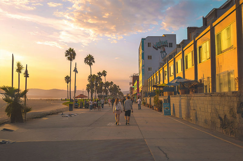 Drone Light Shows in Los Angeles | Creative Skies Drone Light Shows 6 Colorful drone light show illuminating the sky above Venice Beach, with crowds watching from the boardwalk and palm trees silhouetted against the night sky.